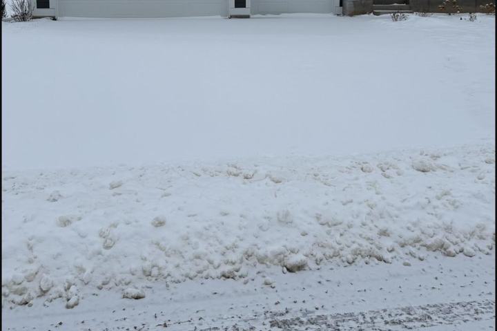 Driveway covered in snow before plowing